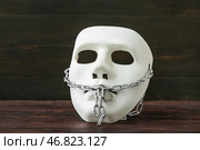 Маска с цепью и замком на темном деревянном фоне. Концепция цензуры. Стоковое фото, фотограф Pixel_shot / Фотобанк Лори