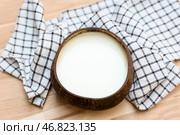 Раковина с кокосовым молоком и салфеткой на деревянном фоне. Стоковое фото, фотограф Pixel_shot / Фотобанк Лори