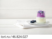 Стакан панна-котты с черникой и красивыми гортензиями на белом деревянном столе. Стоковое фото, фотограф Pixel_shot / Фотобанк Лори