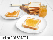 Доска и тарелки с вкусными грилями, абрикосовым джемом и ножом на белом деревянном фоне. Стоковое фото, фотограф Pixel_shot / Фотобанк Лори