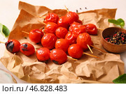Бумага для выпечки и шампуры с вкусными жареными помидорами на белом фоне. Стоковое фото, фотограф Pixel_shot / Фотобанк Лори