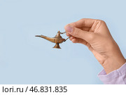 Молодая мусульманка с лампой Аладдина на фоне синего цвета, крупным планом. Празднование исламского Нового года. Стоковое фото, фотограф Pixel_shot / Фотобанк Лори