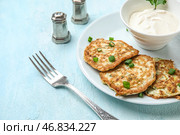 Тарелка вкусных кабачковых оладий с сметаной на светлом фоне. Стоковое фото, фотограф Pixel_shot / Фотобанк Лори
