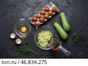 Чашка с тертыми цуккини и ингредиенты для приготовления оладий на черном фоне. Стоковое фото, фотограф Pixel_shot / Фотобанк Лори