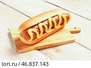 Доска с вкусным хот-догом на белом деревянном фоне. Стоковое фото, фотограф Pixel_shot / Фотобанк Лори