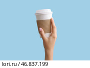 Женская рука с взятой бумажной чашкой на синем фоне. Стоковое фото, фотограф Pixel_shot / Фотобанк Лори