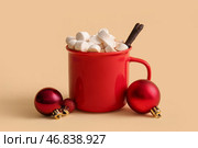 Чашка горячего какао с маршмеллоу и рождественскими шариками на желтом фоне. Стоковое фото, фотограф Pixel_shot / Фотобанк Лори