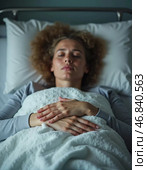 In a serene hospital room, a sick woman lies peacefully in bed, wrapped in a warm blanket. Her expression reflects inner strength and the hope to overcome hardships ahead. Стоковое AI-изображение, AI-художник Юлия Петровская / Фотобанк Лори