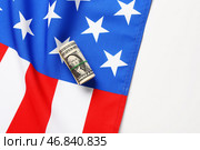 Флаг США и сверток долларовых банкнот на белом фоне. Стоковое фото, фотограф Pixel_shot / Фотобанк Лори