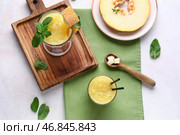 Деревянная доска с бокалами вкусного дынного смузи и мятой на белом фоне. Стоковое фото, фотограф Pixel_shot / Фотобанк Лори