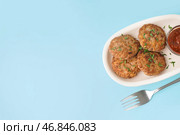 Котлеты с измельченной петрушкой, кетчупом и вилкой на голубом фоне. Стоковое фото, фотограф Pixel_shot / Фотобанк Лори