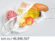 Сетчатый мешок с свежими яблоками, багет и бутылка сокa на белом фоне, крупный план. Стоковое фото, фотограф Pixel_shot / Фотобанк Лори