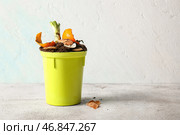 Ведро с органическими отходами и почвой на белом потертом столе. Концепция компостирования и переработки. Стоковое фото, фотограф Pixel_shot / Фотобанк Лори