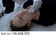 Ultrasound machine doctor conducts examination of thyroid gland of a young woman. Clip. Concept of medicine and health care. Стоковое фото, фотограф Данил Руденко / Фотобанк Лори