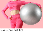 Молодая женщина в спортивной одежде с фитболом на розовом фоне. Стоковое фото, фотограф Pixel_shot / Фотобанк Лори