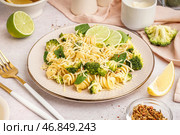 Вкусные фузилли с брокколи, сыром и ломтями лайма на тарелке на светлом фоне, крупным планом. Стоковое фото, фотограф Pixel_shot / Фотобанк Лори
