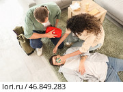 Молодая женщина надевает кислородную маску на без сознания мужчину из-за пожара в здании. Стоковое фото, фотограф Pixel_shot / Фотобанк Лори