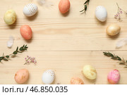 Рамка из покрашенных пасхальных яиц, цветов и веток на светлом деревянном фоне. Стоковое фото, фотограф Pixel_shot / Фотобанк Лори