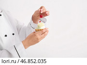 Женский кондитер украшать вкусный торт на белом фоне. Стоковое фото, фотограф Pixel_shot / Фотобанк Лори