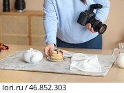 Фотограф-женщина, специализирующаяся на еде, готовится к съемке вкусных блинов в студии, крупным планом. Стоковое фото, фотограф Pixel_shot / Фотобанк Лори