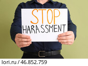 Бизнесмен держит лист бумаги с текстом "СТОП ДОМОГАТЕЛЬСТВА" на зеленом фоне, крупным планом. Стоковое фото, фотограф Pixel_shot / Фотобанк Лори