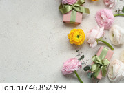 Красивые цветы ранункулюса с эвкалиптом и подарочными коробками на белом фоне с эффектом потертости. Стоковое фото, фотограф Pixel_shot / Фотобанк Лори