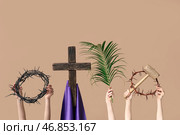 Женские руки с венками из терновника, деревянный крест, молот и ладановая ветвь на цветном фоне. Концепция Страстной Пятницы. Стоковое фото, фотограф Pixel_shot / Фотобанк Лори