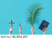 Женские руки с деревянным крестом, гвоздями, ладаном и Священной Библией на цветном фоне. Концепция Великой Пятницы. Стоковое фото, фотограф Pixel_shot / Фотобанк Лори