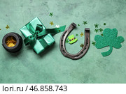 Подарочная коробка с горшочком монет, подковой и декорациями к дню святого Патрика на зеленом гранжевом фоне. Стоковое фото, фотограф Pixel_shot / Фотобанк Лори