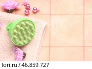 Массажер для кожи головы с капсулами, полотенцем и цветами хризантем на розовом плиточном фоне. Стоковое фото, фотограф Pixel_shot / Фотобанк Лори