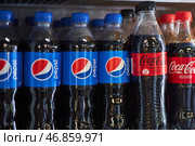 Competing brand plastic soda bottles on one shelf at supermarket. Pepsi and Coca Cola. Bishkek, Kyrgyzstan - 26 May 2023. Редакционное фото, фотограф Екатерина Якименко / Фотобанк Лори