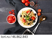 Тарелка с вкусным салатом из макарон и ингредиентами на темном деревянном фоне. Стоковое фото, фотограф Pixel_shot / Фотобанк Лори