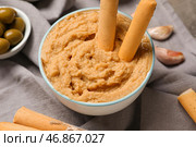 Чаша с вкусным хумусом и итальянским гриссини на столе, крупным планом. Стоковое фото, фотограф Pixel_shot / Фотобанк Лори