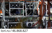 Mining farm for cryptocurrency, electronic devices with wires and cables. Стоковое фото, фотограф David Kashakhi / Фотобанк Лори