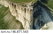 A view over white mountain cliffs, with hills and valleys, with green meadows on blue sky background. Стоковое фото, фотограф David Kashakhi / Фотобанк Лори