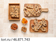 Композиция с вкусным печеньем бискотти, орехами и курагой на фоне светлой плитки. Стоковое фото, фотограф Pixel_shot / Фотобанк Лори
