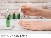Женщина наносит масло на кутикулу на светлом деревянном фоне, крупным планом. Стоковое фото, фотограф Pixel_shot / Фотобанк Лори