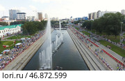Aerial view of the Yekaterinburg city embankment and the Iset river with the crowd of people walking nearby. Стоковое фото, фотограф David Kashakhi / Фотобанк Лори