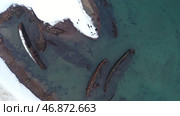 Top view of many old wrecked ships drowned at the sea shore in snowy winter season. Стоковое фото, фотограф David Kashakhi / Фотобанк Лори