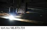 The laser cutter machine while cutting the sheet metal with the sparking light. Стоковое фото, фотограф David Kashakhi / Фотобанк Лори