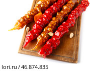Доска с вкусной чурчхелой, курагой и фисташками на белом фоне. Стоковое фото, фотограф Pixel_shot / Фотобанк Лори
