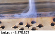 Macro Close Up Of Burning Incense Sticks With Smoke Over Brown Background. Стоковое фото, фотограф David Kashakhi / Фотобанк Лори