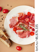 Тарелка с вкусными ломтиками хамона на бежевом фоне. Стоковое фото, фотограф Pixel_shot / Фотобанк Лори