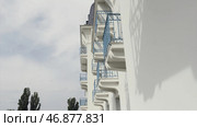 Side view of balconies with blue wrought iron railing of modern building, architectural background. Стоковое фото, фотограф David Kashakhi / Фотобанк Лори