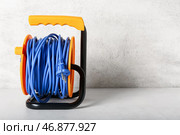Катушка с удлинителем электрического кабеля на светлом фоне. Стоковое фото, фотограф Pixel_shot / Фотобанк Лори