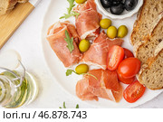 Тарелка с ломтиками вкусного хамона на светлом фоне, крупным планом. Стоковое фото, фотограф Pixel_shot / Фотобанк Лори