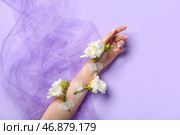 Женщина с проклеенными белыми цветами и вуалью на сиреневом фоне. Концепция ухода за руками. Стоковое фото, фотограф Pixel_shot / Фотобанк Лори