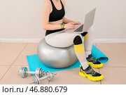 Спортивная женщина с ноутбуком на фитболе в тренажерном зале. Стоковое фото, фотограф Pixel_shot / Фотобанк Лори