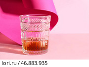 Стакан рома с кубиками льда на розовом фоне. Стоковое фото, фотограф Pixel_shot / Фотобанк Лори