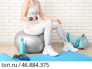 Спортивная женщина тренируется с гантелями на фитболе в тренажерном зале. Стоковое фото, фотограф Pixel_shot / Фотобанк Лори